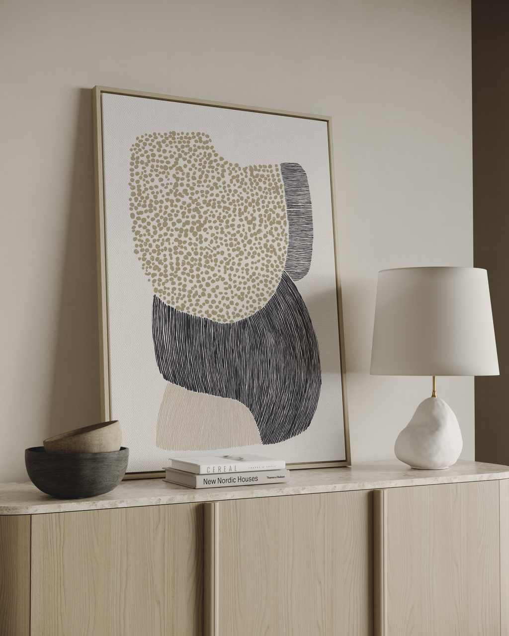 Abstract art piece on a wall above a wooden cabinet with decor items.